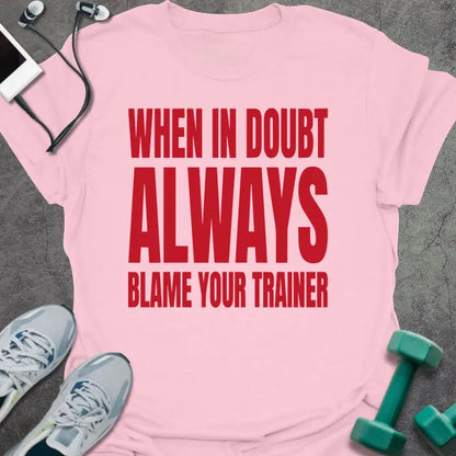 Light pink t-shirt printed with "When in Doubt Always Blame Your Trainer" in red and white