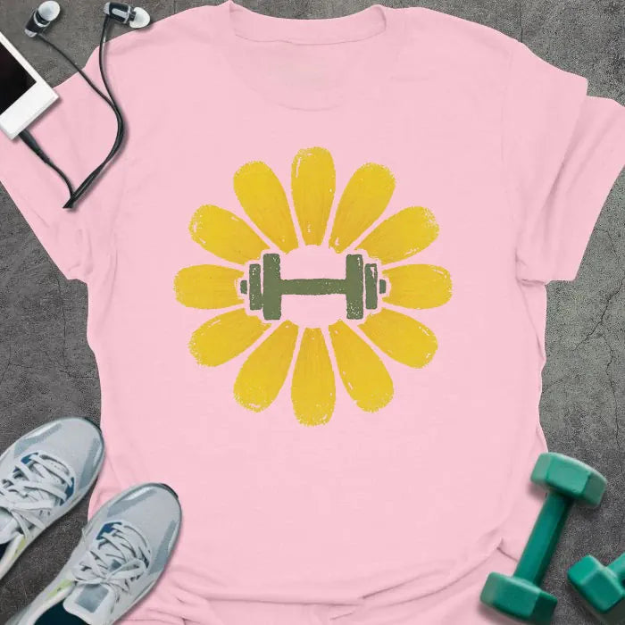 Light pink t-shirt with an illustration of a dandelion flower surrounding a dumbbell in yellow and green