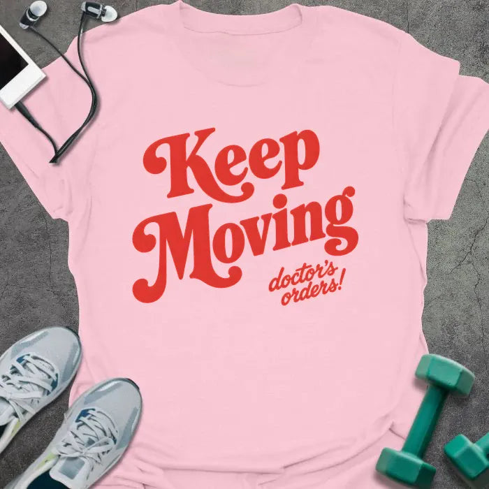 Light Pink t-shirt printed with "Keep Moving doctor's orders!" in red script lettering