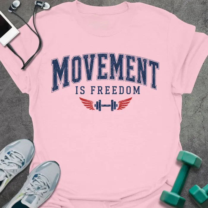 Light pink t-shirt printed with "Movement is Freedom" in blue and red, with red winged barbells