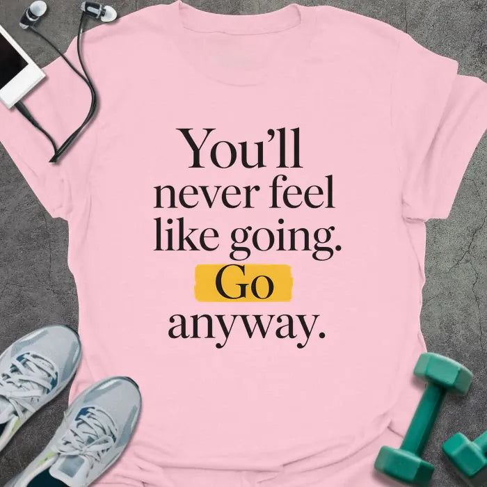 Light pink t-shirt printed with "You'll never feel like going. Go anyway." in black and yellow