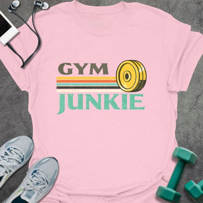 Light pink t-shirt printed with "Gym Junkie" in olive green, yellow, orange, white, with a yellow kettlebell and rainbow stripe
