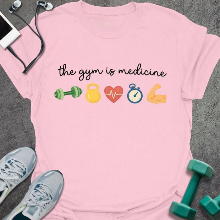 Light pink t-shirt printed with "the gym is medicine" in multicolor, with emoji icons of gym equipment