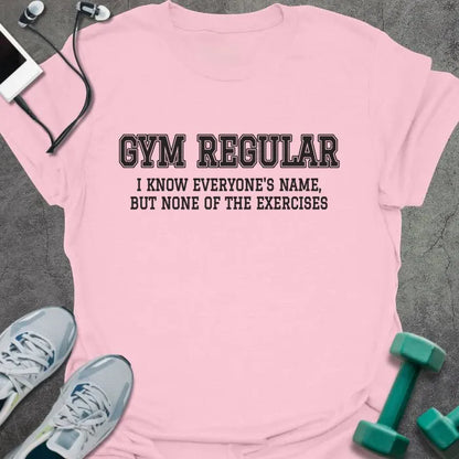 Light pink t-shirt printed with "GYM REGULAR, I KNOW EVERYONE'S NAME, BUT NONE OF THE EXERCISES" in charcoal