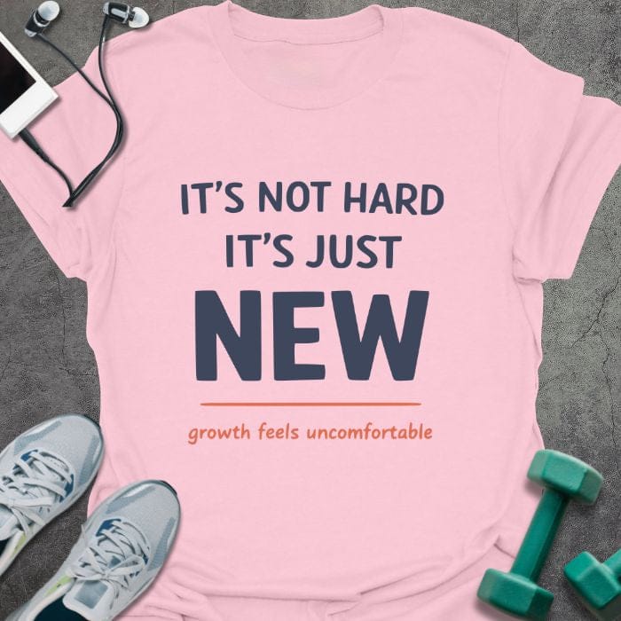 Light pink t-shirt printed with "IT'S NOT HARD IT'S JUST NEW growth feels uncomfortable" in red
