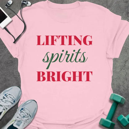 Light pink t-shirt printed with "LIFTING spirits BRIGHT" in red and green