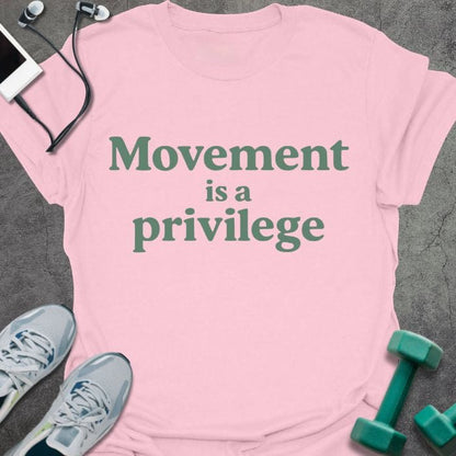 Light pink t-shirt printed with "Movement is a privilege" in green