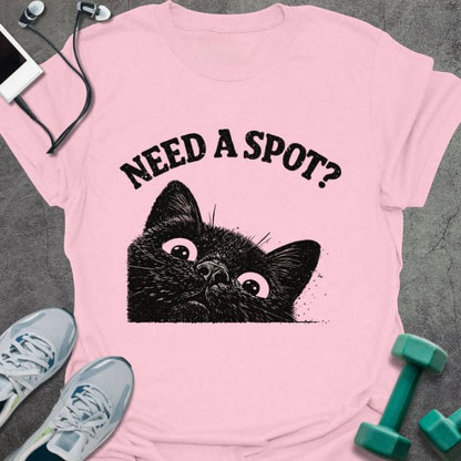 Light pink t-shirt printed with "Need a Spot?" in black, with an illustration of a cat's face looking up