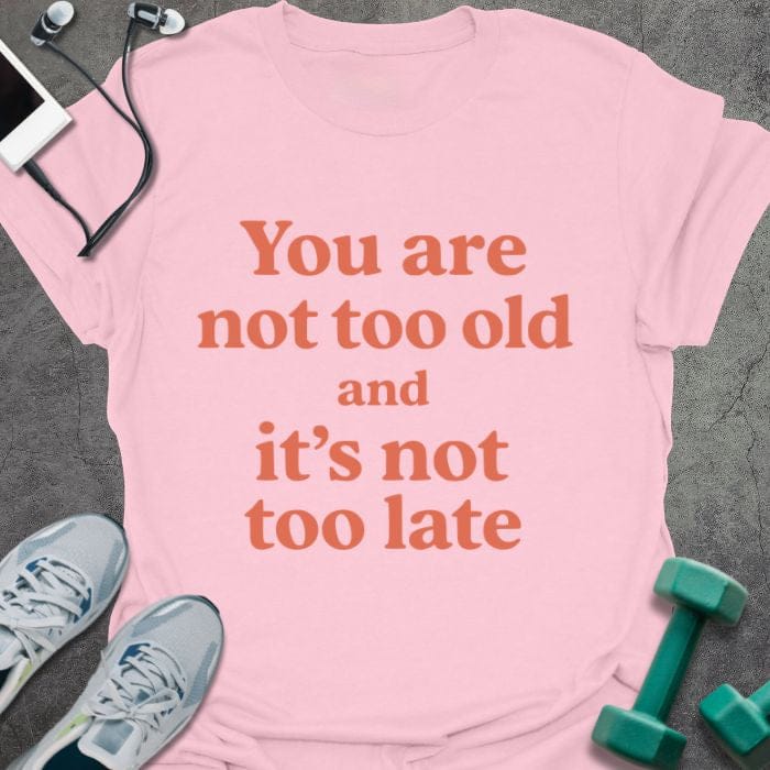 Light pink t-shirt printed with "You are not too old and it's not too late" in red