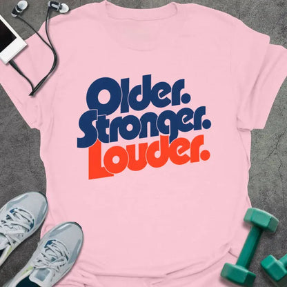 Light Pink t-shirt printed with "Older. Stronger. Louder." in navy blue with orange bold lettering