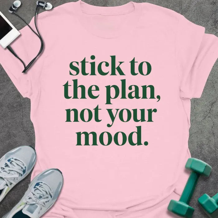 Light pink t-shirt printed with "stick to the plan, not your mood." in green