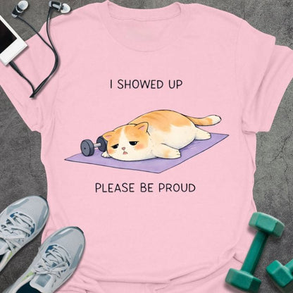Light pink t-shirt printed with "I Showed Up Please Be Proud" in orange, white, purple, with an orange and white cat on a purple yoga mat