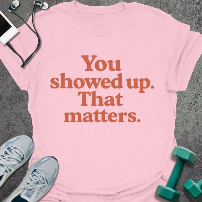 Light pink t-shirt printed with "You showed up. That matters." in red