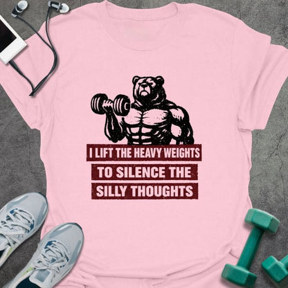 Light pink t-shirt printed with "I Lift the Heavy Weights to Silence the Silly Thoughts" in red and black, with muscular bear lifting dumbbell