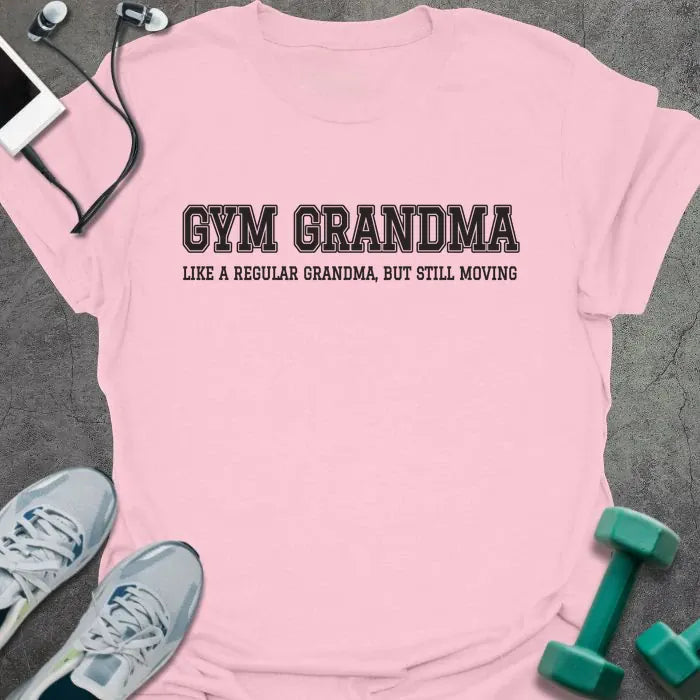 Light pink t-shirt printed with "GYM GRANDMA, LIKE A REGULAR GRANDMA, BUT STILL MOVING" in charcoal varsity letters