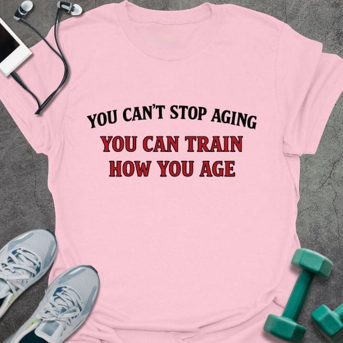 Light pink t-shirt printed with "You Can't Stop Aging You Can Train How You Age" in red and black