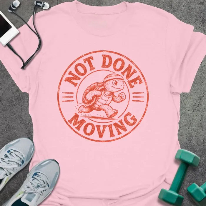 Light Pink t-shirt printed with "NOT DONE MOVING" in coral, with running turtle in circle