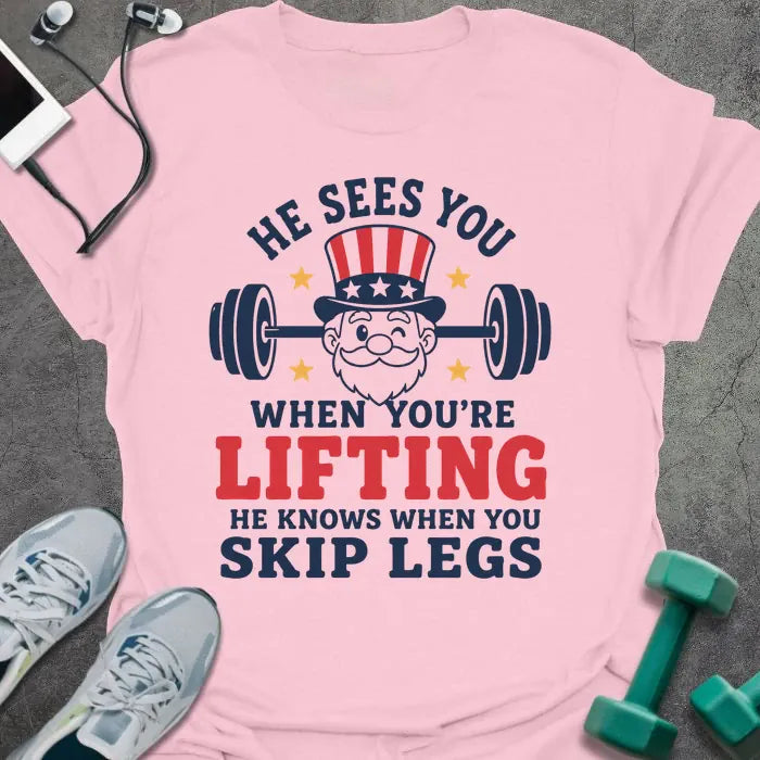 Light pink t-shirt with an American flag person lifting dumbbells graphic in white and red