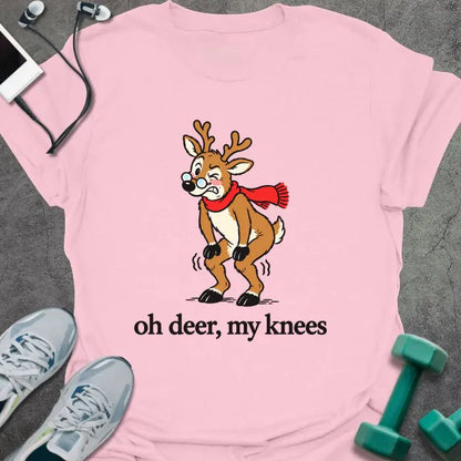Light pink t-shirt printed with "oh deer, my knees" in black, with a vintage cartoon reindeer in glasses and a red scarf holding its knees