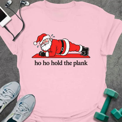 Light pink t-shirt printed with "ho ho hold the plank" in black, with Santa holding a plank on a red mat