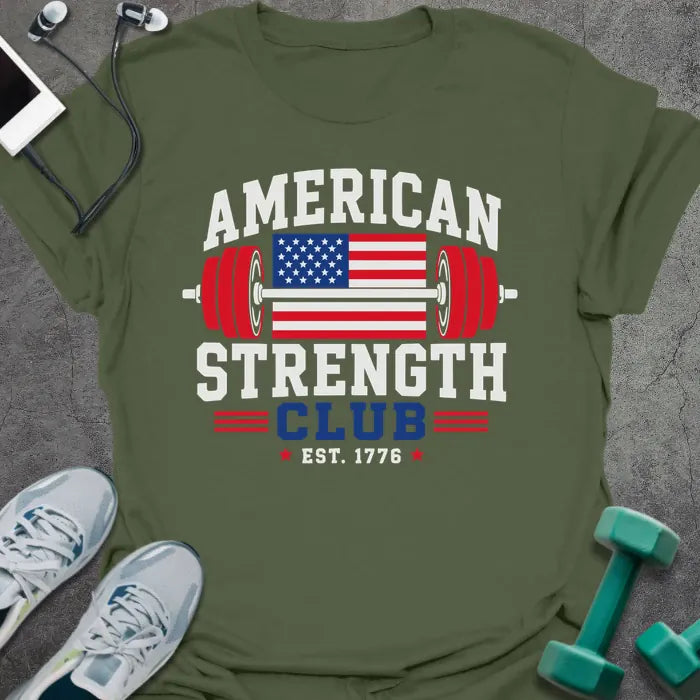 Military green t-shirt printed with "American Strength Club Est. 1776" in white, red, and blue, with a stars-and-stripes barbell and eagle