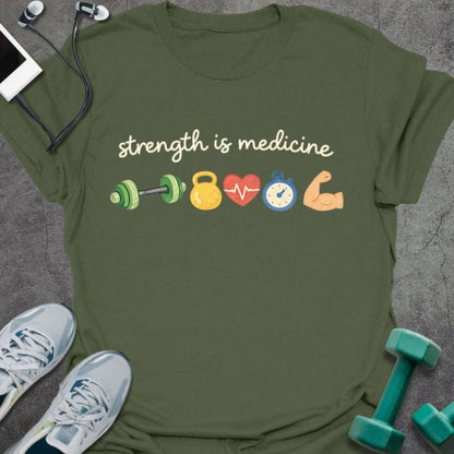 Military green t-shirt printed with "strength is medicine" in multicolor, with emoji icons: dumbbell, kettlebell, heart, timer, muscle