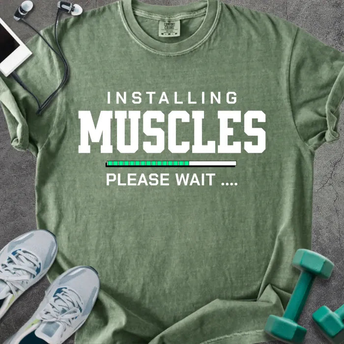 Moss t-shirt printed with "Installing Muscles Please Wait ...." in white and multicolor, with a loading bar
