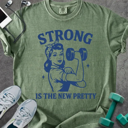 Moss t-shirt printed with "Strong is the New Pretty" in blue, with a Rosie the Riveter figure with a dumbbell