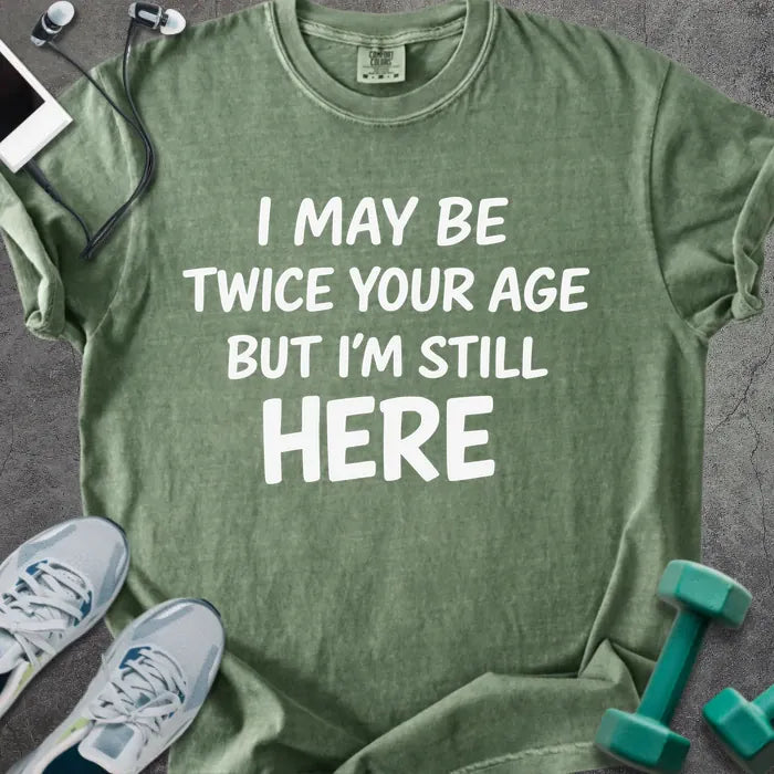 Moss t-shirt printed with "I May Be Twice Your Age but I'm Still Here" in white