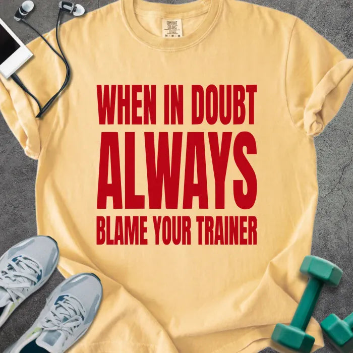 Mustard t-shirt printed with "When in Doubt Always Blame Your Trainer" in red