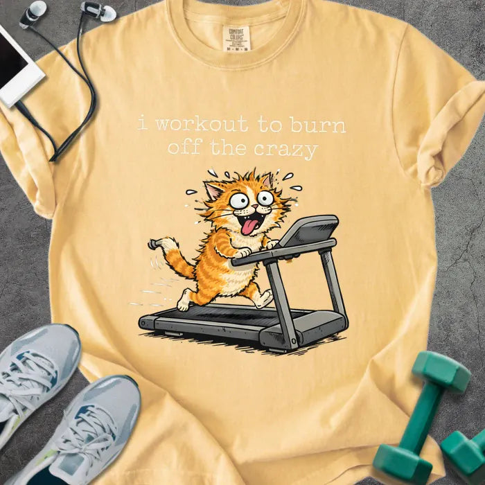 Mustard t-shirt printed with "i workout to burn off the crazy" in orange, with a cat running on a treadmill