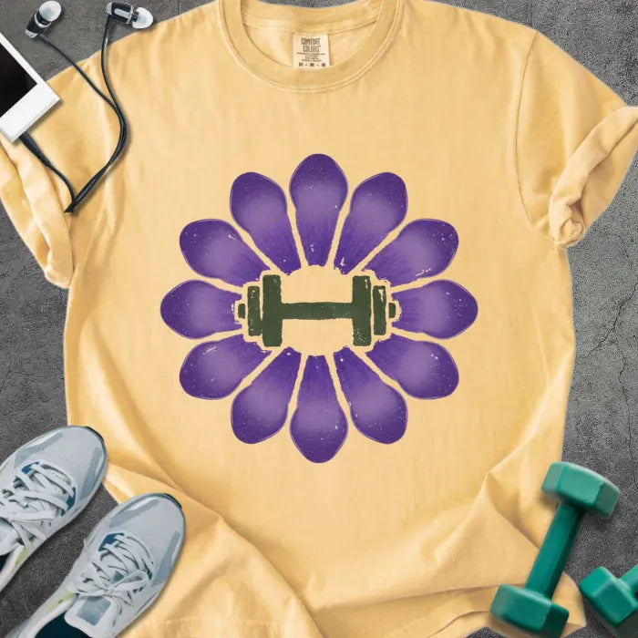 Mustard t-shirt with purple crocus flowers and dumbbell in center in purple and green