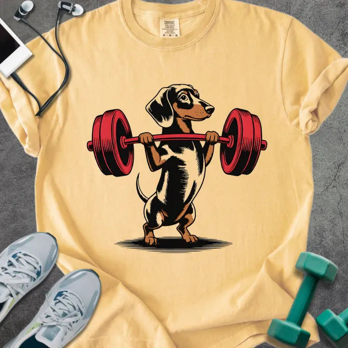 Mustard t-shirt with a dachshund dog lifting a barbell in red