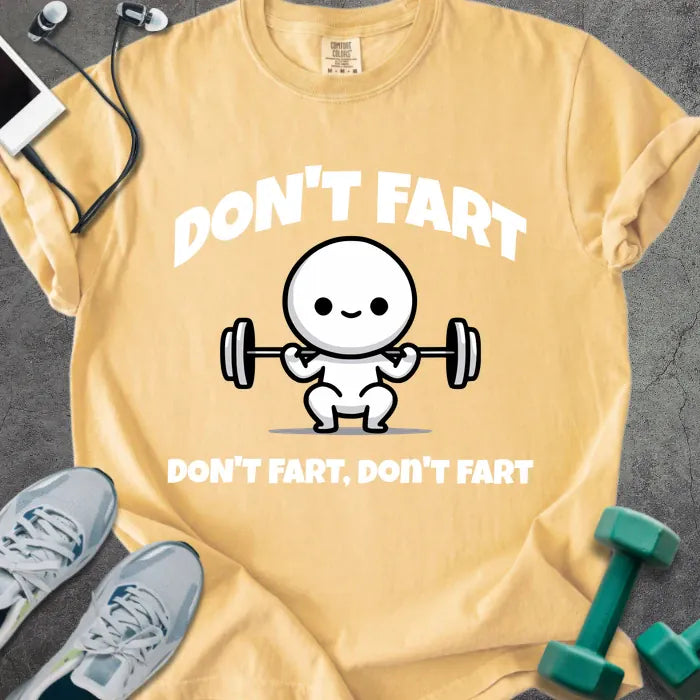Mustard t-shirt printed with "Don't Fart Don't Fart, Don't Fart" in white, with a smiling stick figure lifting weights