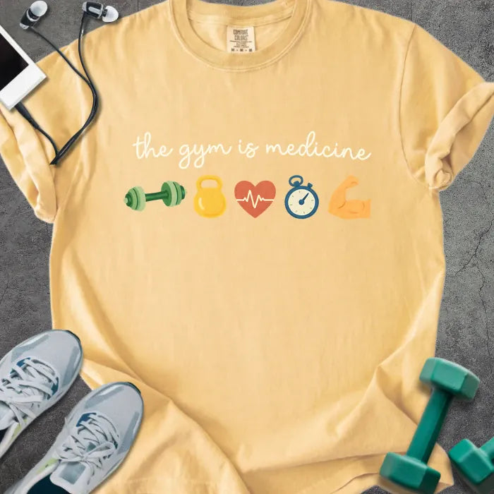Mustard t-shirt printed with "the gym is medicine 💪 🏋️ 💓 ⏰ 💪" in white and multicolor