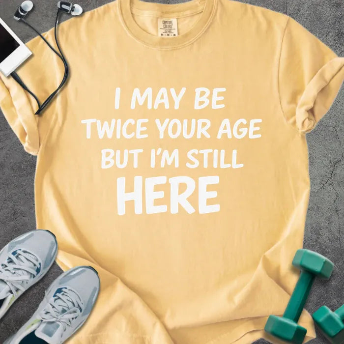 Mustard t-shirt printed with "I May Be Twice Your Age but I'm Still Here" in white