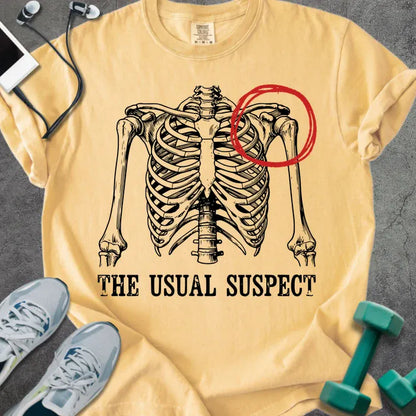 Mustard t-shirt printed with "The Usual Suspect", with skeleton ribcage and red circled heart