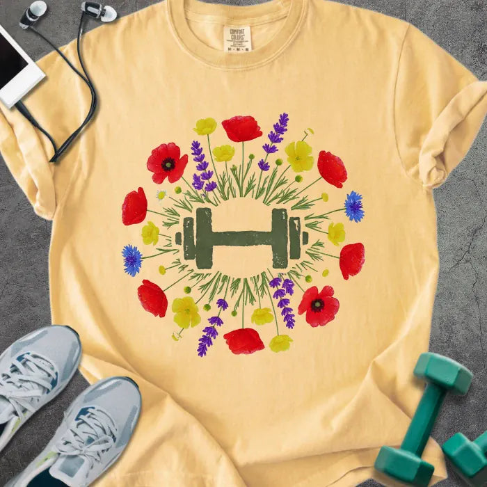 Mustard t-shirt with colorful wildflowers and dumbbells in circular arrangement in red, yellow, purple, blue, and green