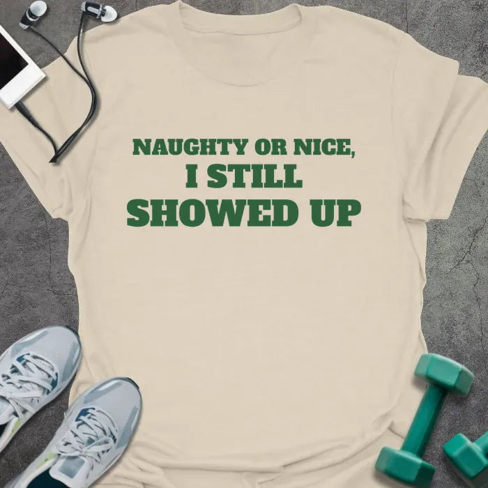 Natural t-shirt printed with "NAUGHTY OR NICE, I STILL SHOWED UP" in green