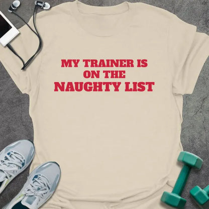 Natural t-shirt printed with "MY TRAINER IS ON THE NAUGHTY LIST" in red