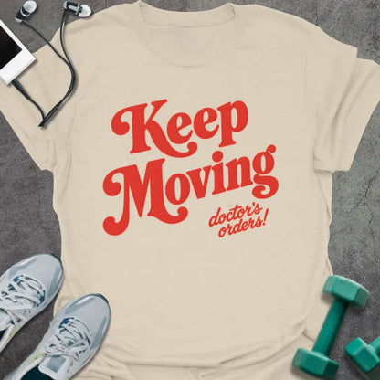 Natural t-shirt printed with "Keep Moving doctor's orders!" in red script lettering