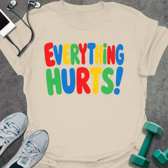 Natural t-shirt printed with "EVERYTHING HURTS!" in rainbow