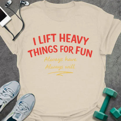 Cream t-shirt printed with "I LIFT HEAVY THINGS FOR FUN Always have. Always will." in black, with a retro illustration of a woman lifting a barbell