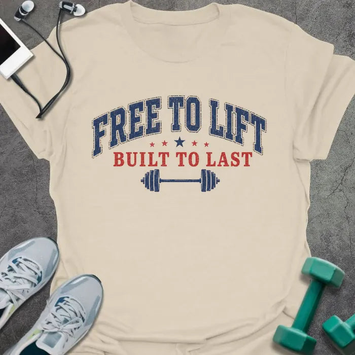 Cream t-shirt printed with "Free to Lift Built to Last" in blue and red, with stars and a barbell