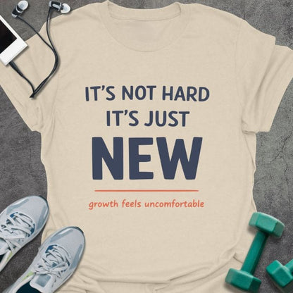 Cream t-shirt printed with "IT'S NOT HARD IT'S JUST NEW growth feels uncomfortable" in red