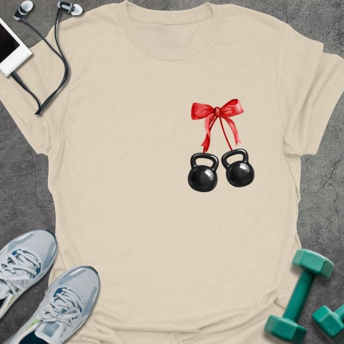 Cream t-shirt with two kettlebells tied with a red ribbon in red, white