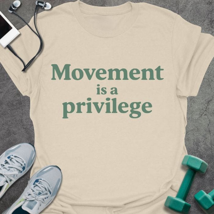 Cream t-shirt printed with "Movement is a privilege" in green