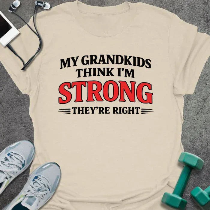 Cream t-shirt printed with "My Grandkids Think I'm Strong They're Right" in black and red
