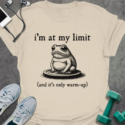 Cream t-shirt printed with "i'm at my limit (and it's only warm-up)" in black, with an illustration of a frog sitting