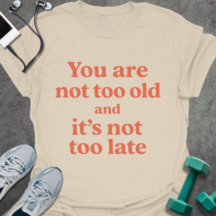 Cream t-shirt printed with "You are not too old and it's not too late" in red